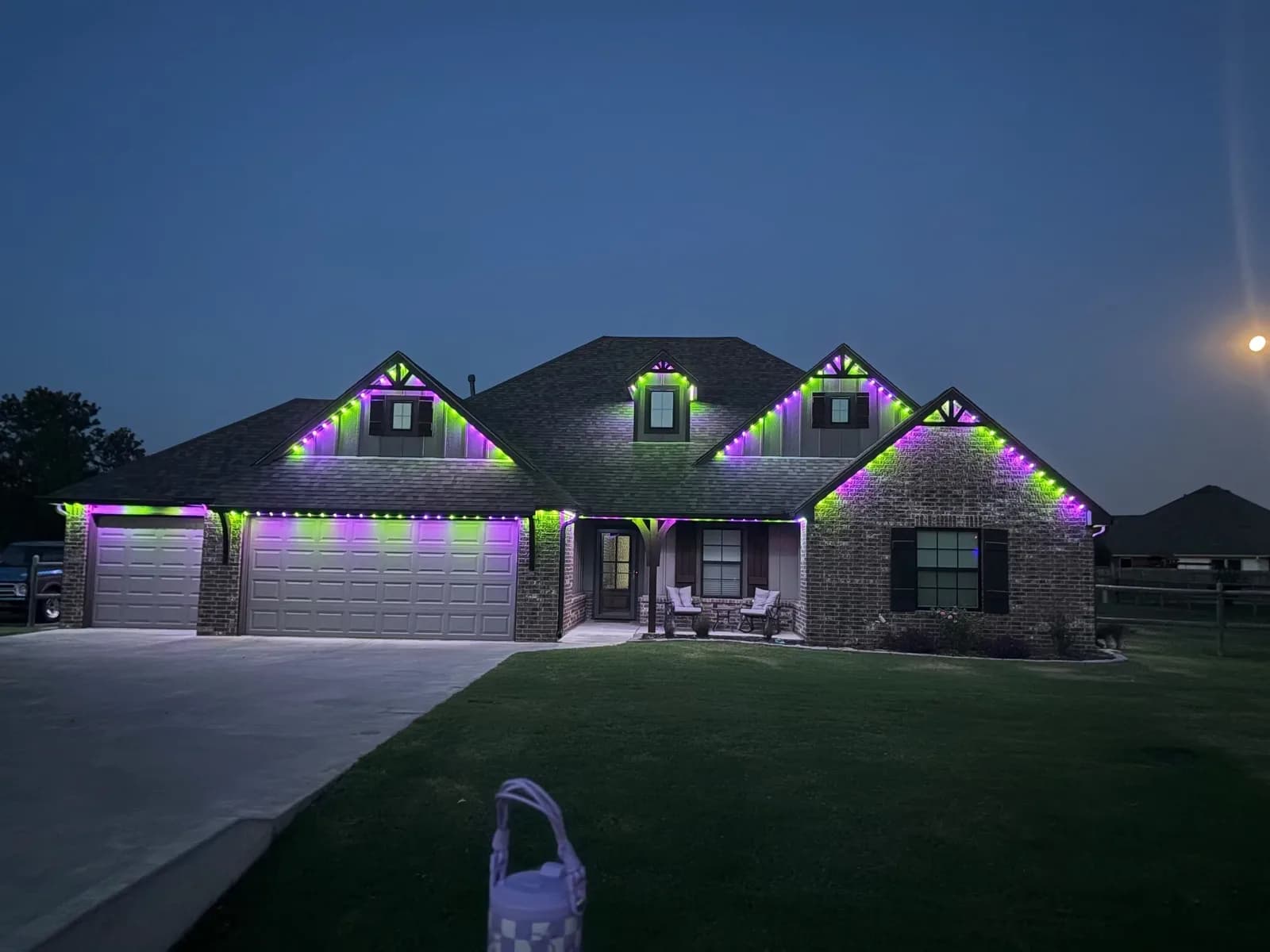 Ranch home in green and purple roofline lights