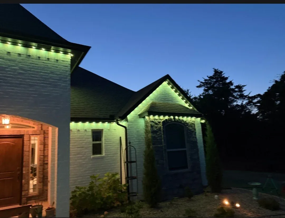 Stone home washed in green at dusk