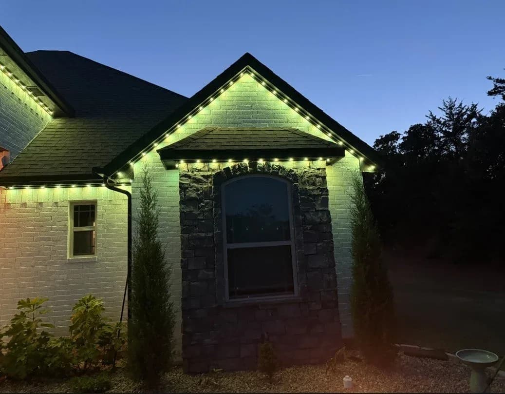 Stone and brick home outlined in green and white