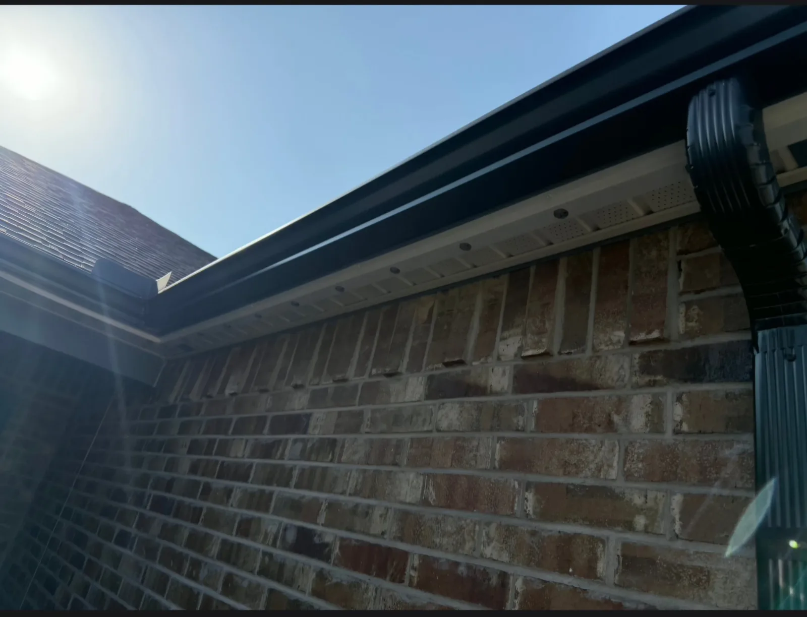 Seamless gutter and downspout detail on a brick home