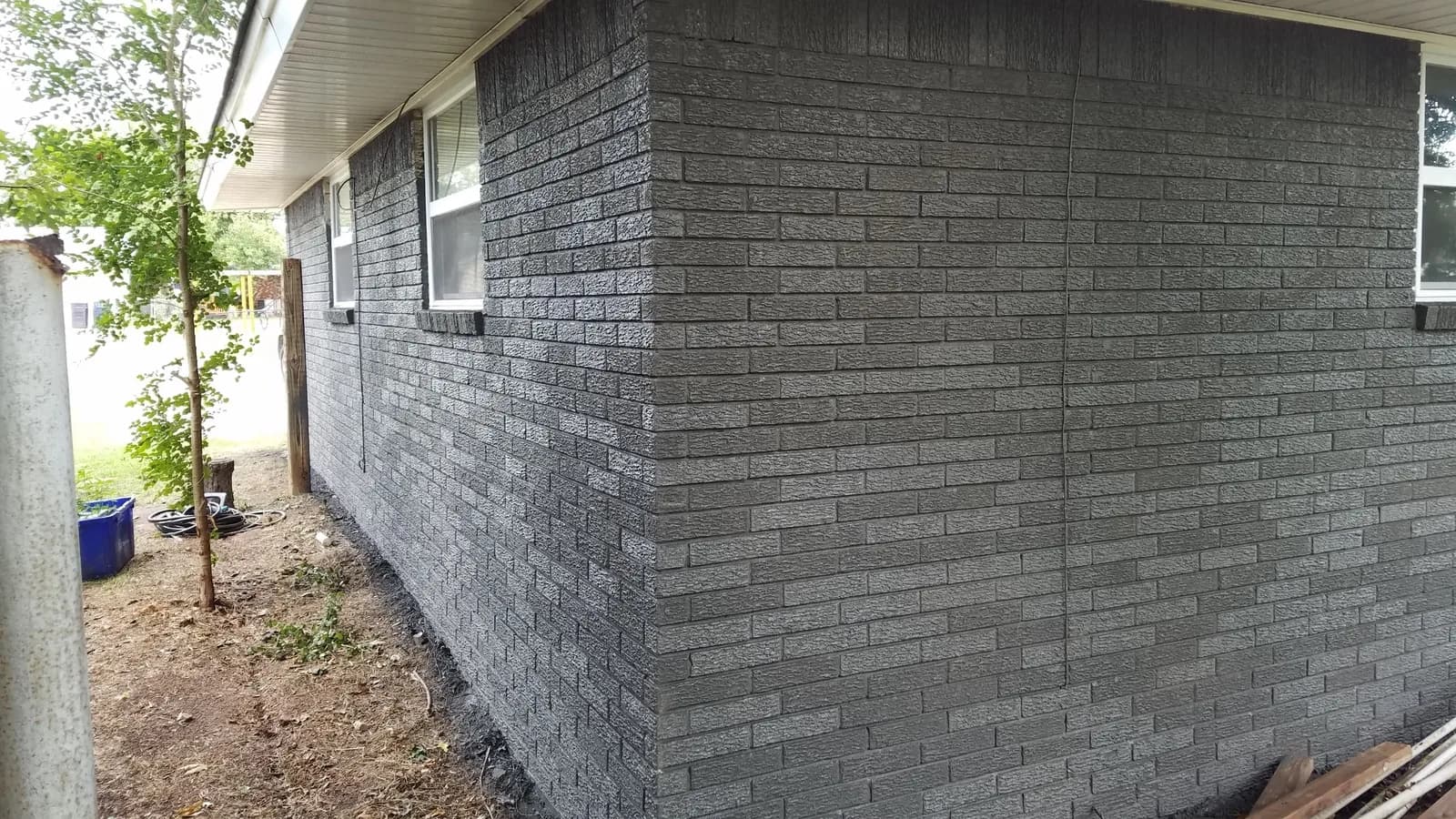 Gutter and downspout on a gray brick wall