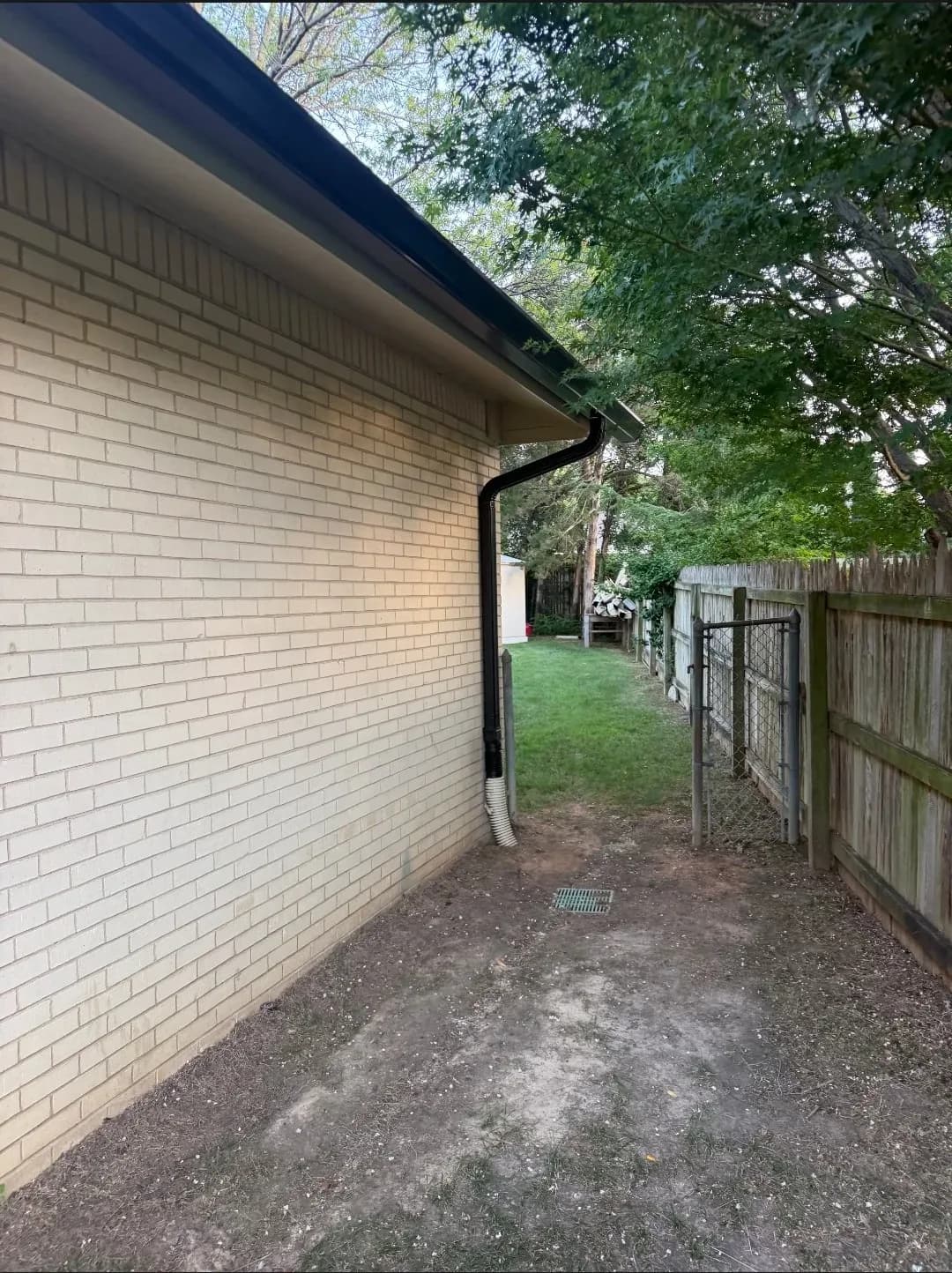 Downspout run down a brick side yard